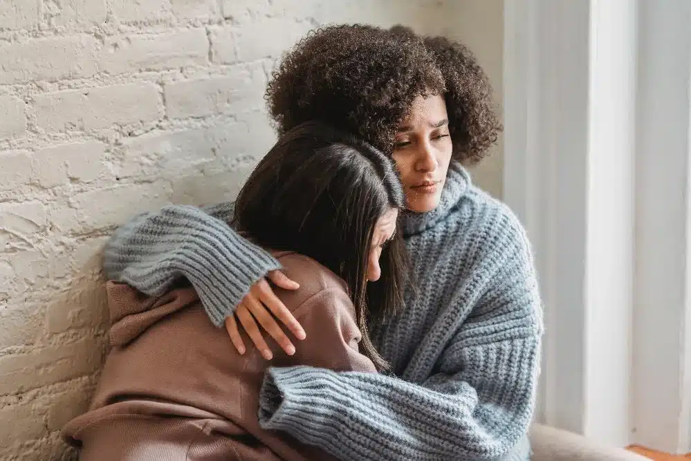 Two people hugging as a result of suffering a loss